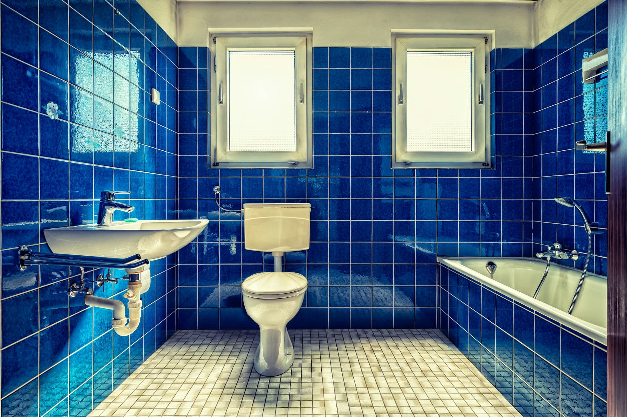Antes: baño con azulejo azul de los años setenta, bañera y bidé.