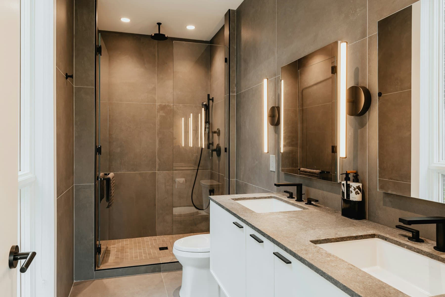 Baño reformado con mueble doble de lavabo y ducha de obra.
