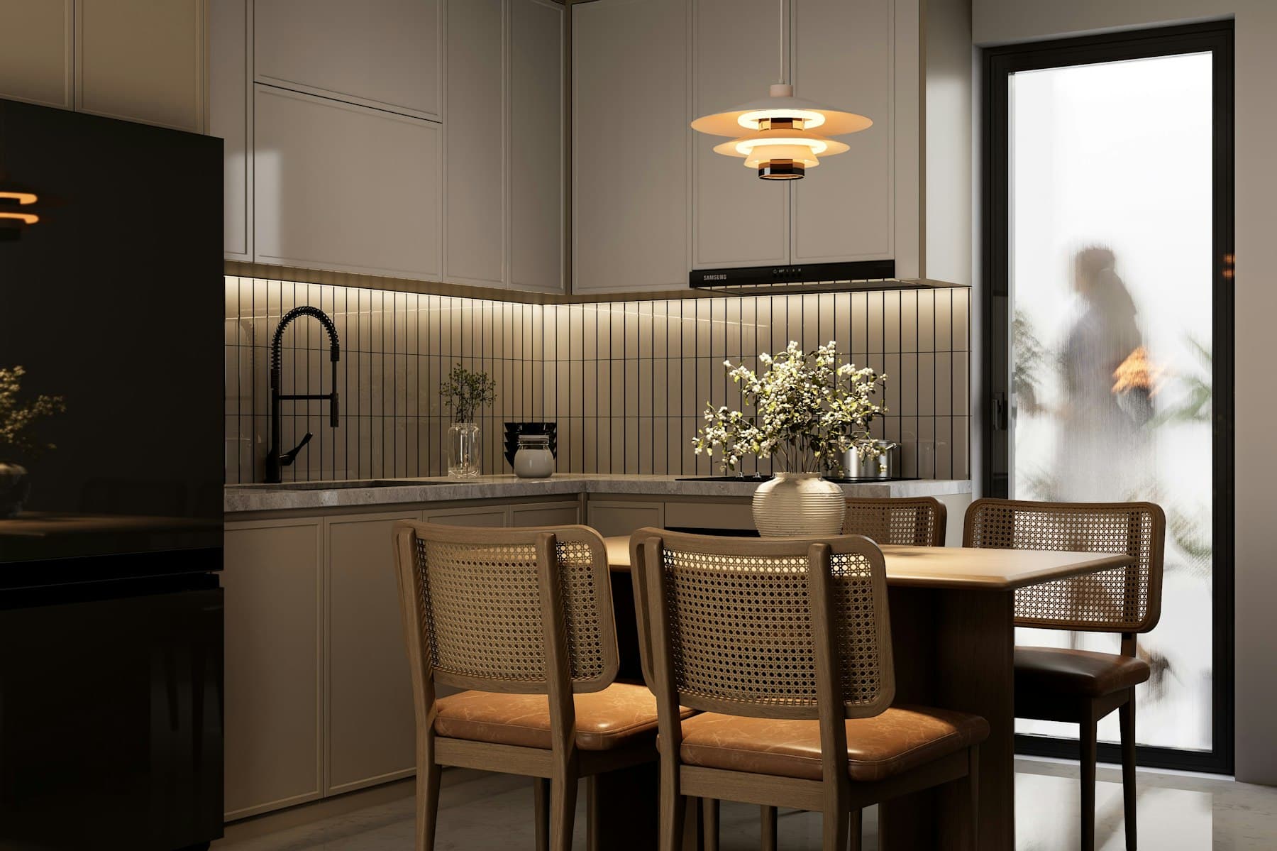 Cocina en tonos piedra con azulejo vertical y mesa con sillas de rejilla.